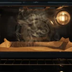 Wax paper melting on a baking tray inside a hot oven, showing why it is unsafe for high-temperature baking