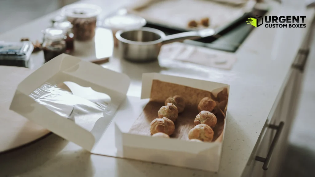 Fresh cream puffs in an open white food-safe paperboard box