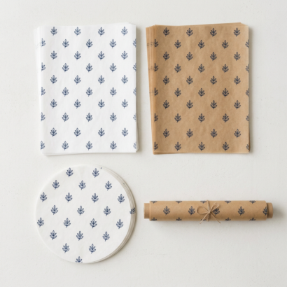 White and unbleached custom parchment sheets, a parchment round and a roll printed with a logo pattern