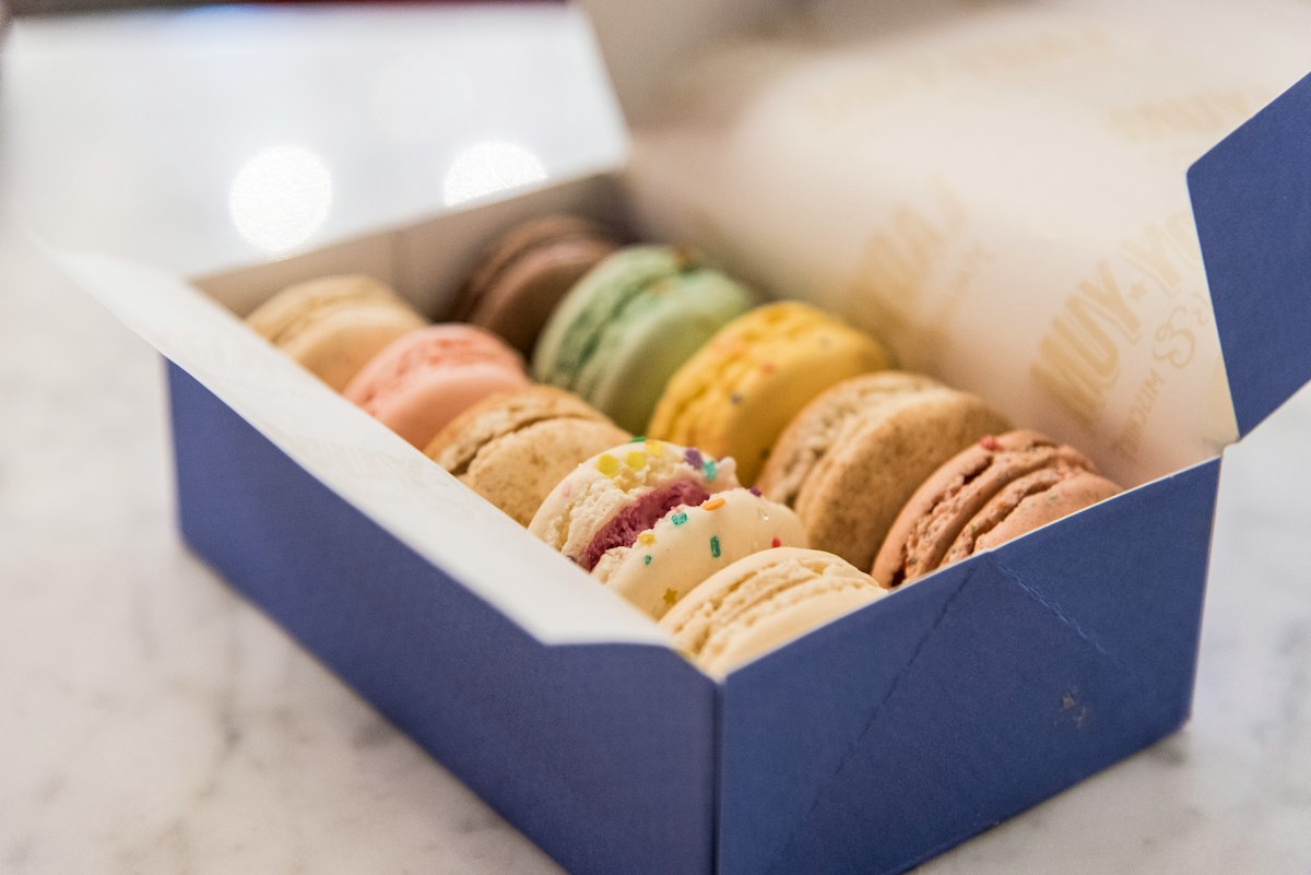 Open macaron box with macarons sitting on edge in rows